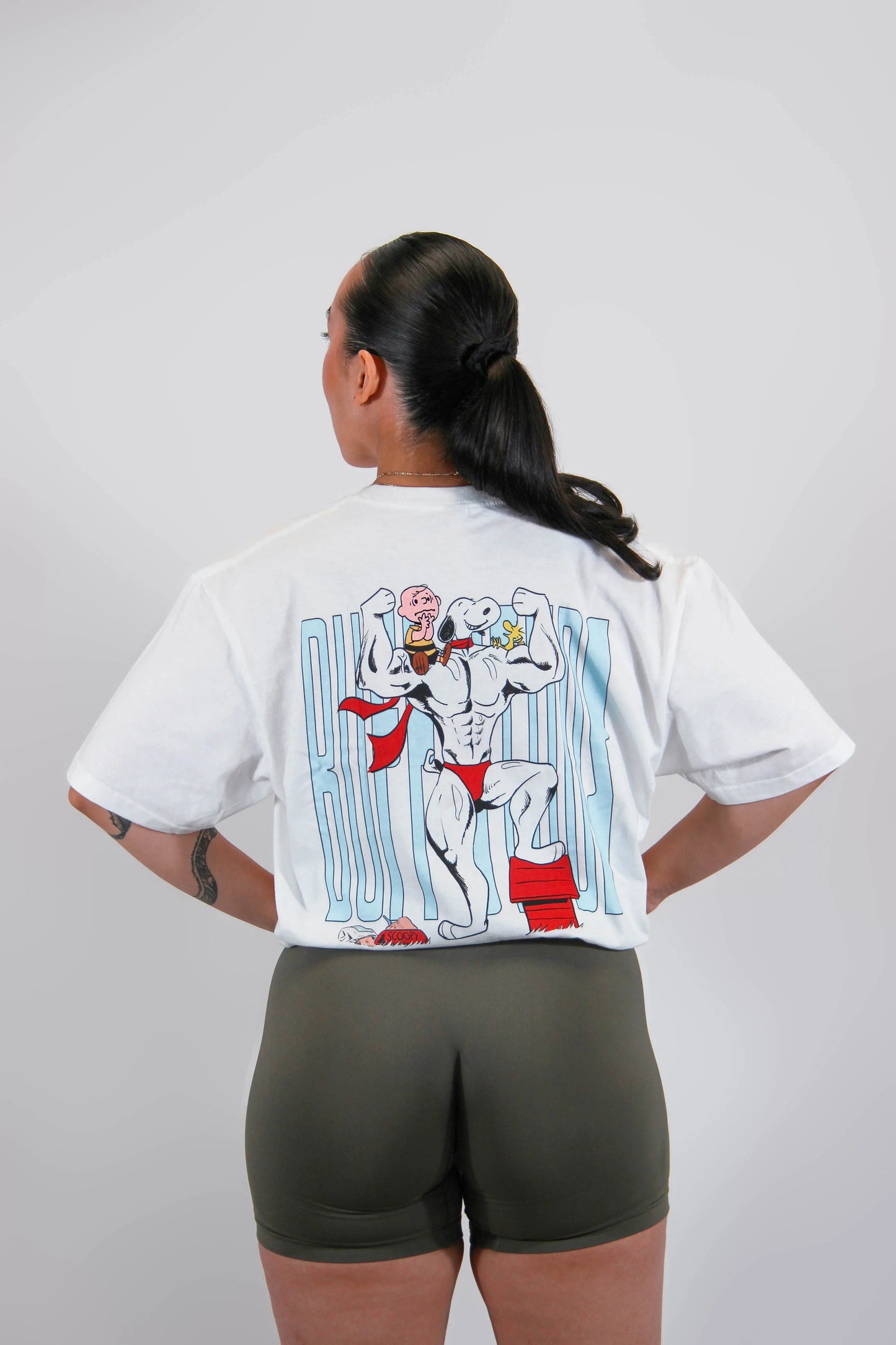 Back view of a model wearing the Classic Buff Tee, showcasing the unique Scoopy graphic design.