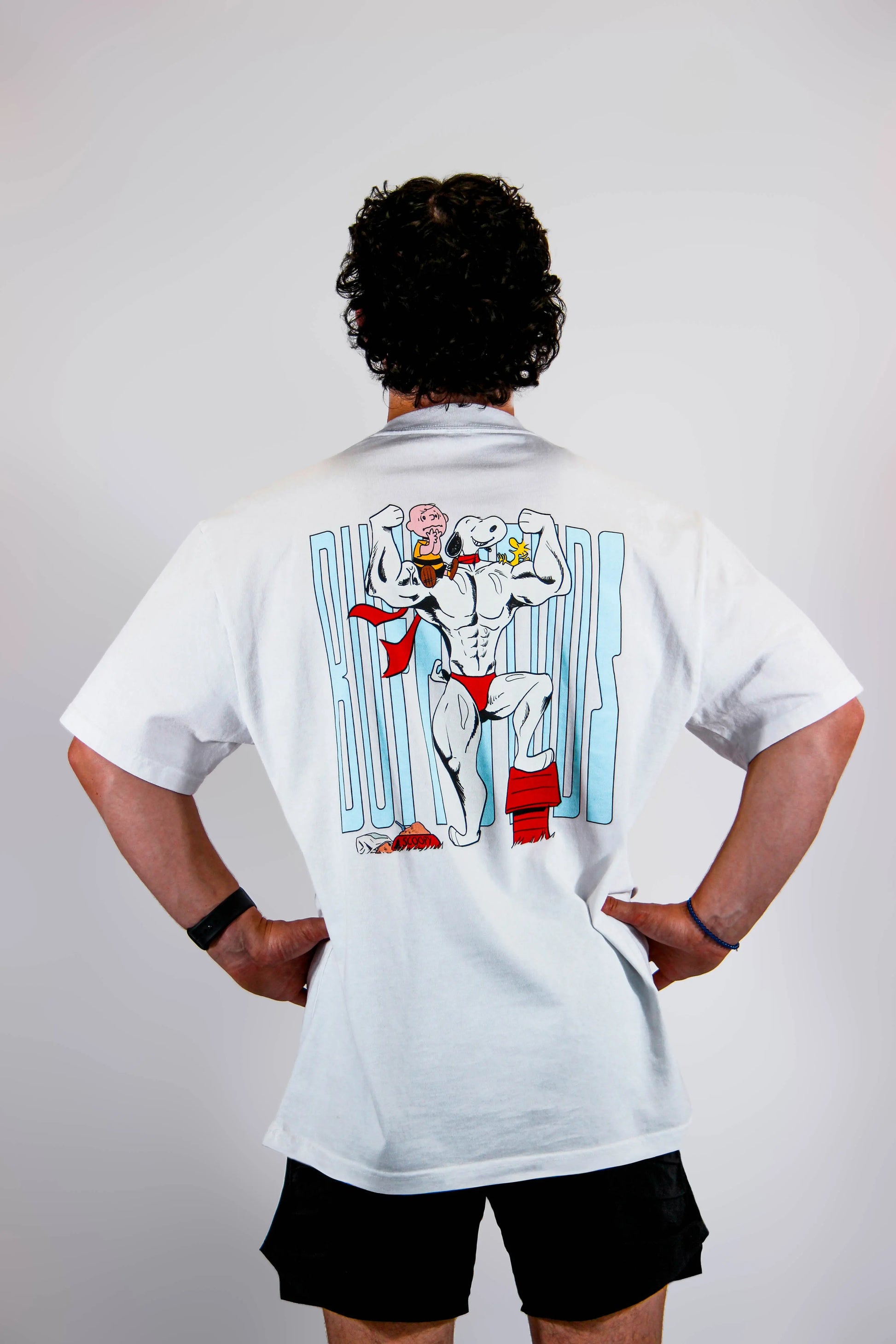 Back view of a model wearing the Classic Buff Tee, showcasing the unique Scoopy graphic design.