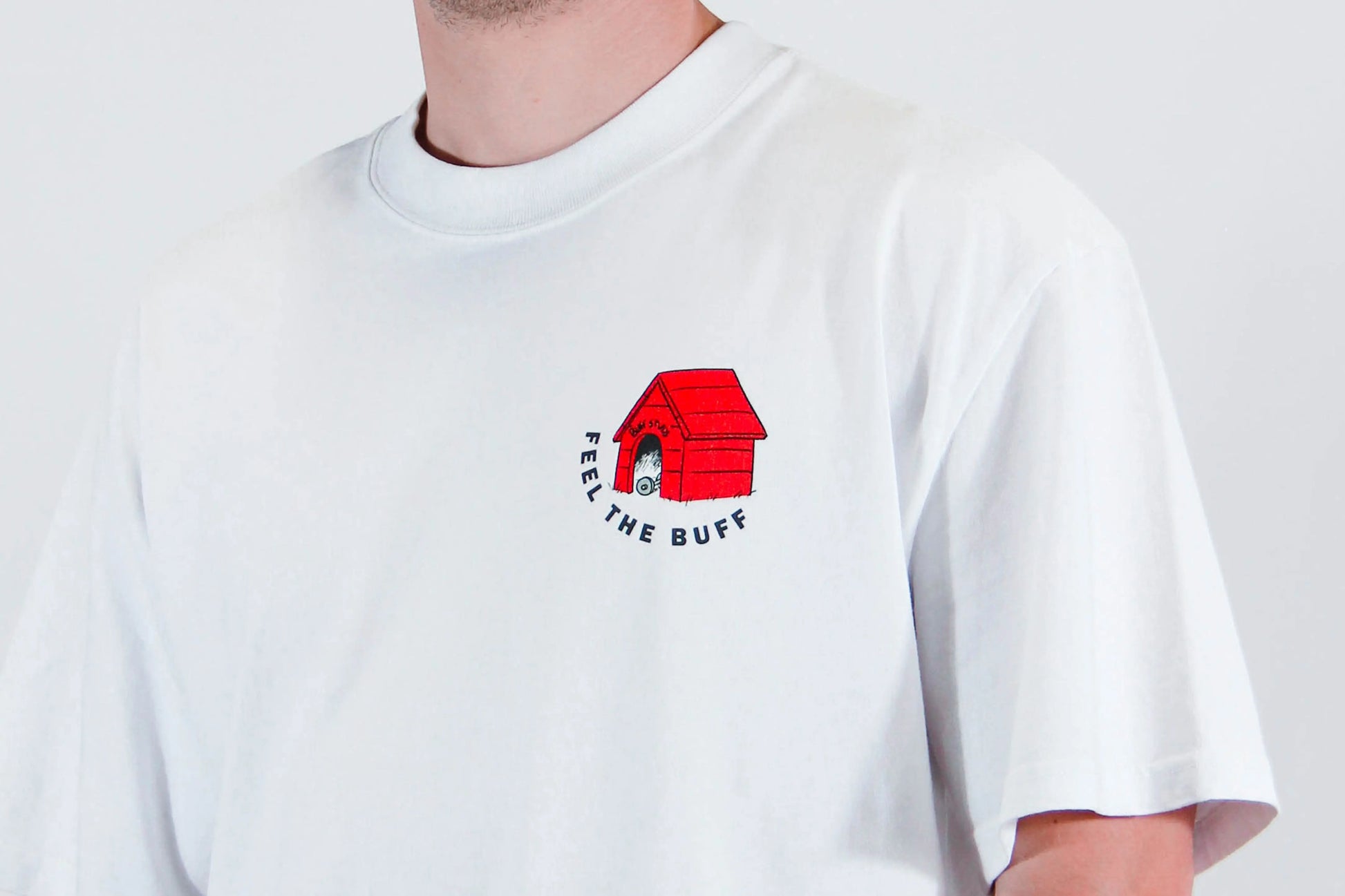 Close-up of the dog house graphic on the front of the Classic Buff Tee, part of the unique design inspired by Scoopy.